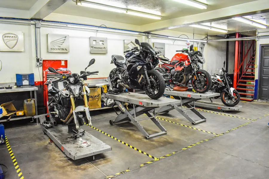 Motosiklet servis atölyesi — liftlerde bakımda bekleyen motosikletler