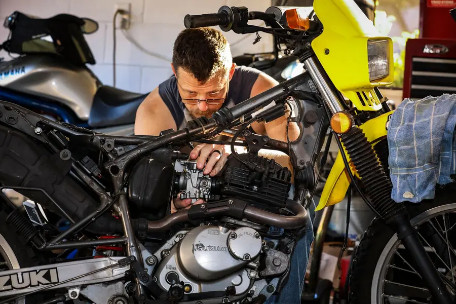 Motosiklet motoruna müdahale eden usta — atölyede periyodik bakım ve arıza onarımı